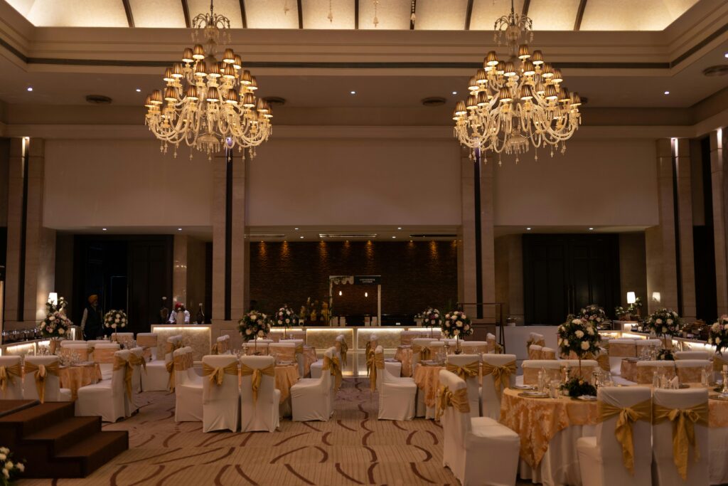 Luxurious ballroom decorated with grand chandeliers and floral arrangements for an elegant event.